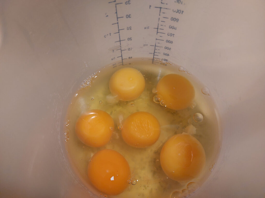frische aufgeschlagene Eier im Meßbecher