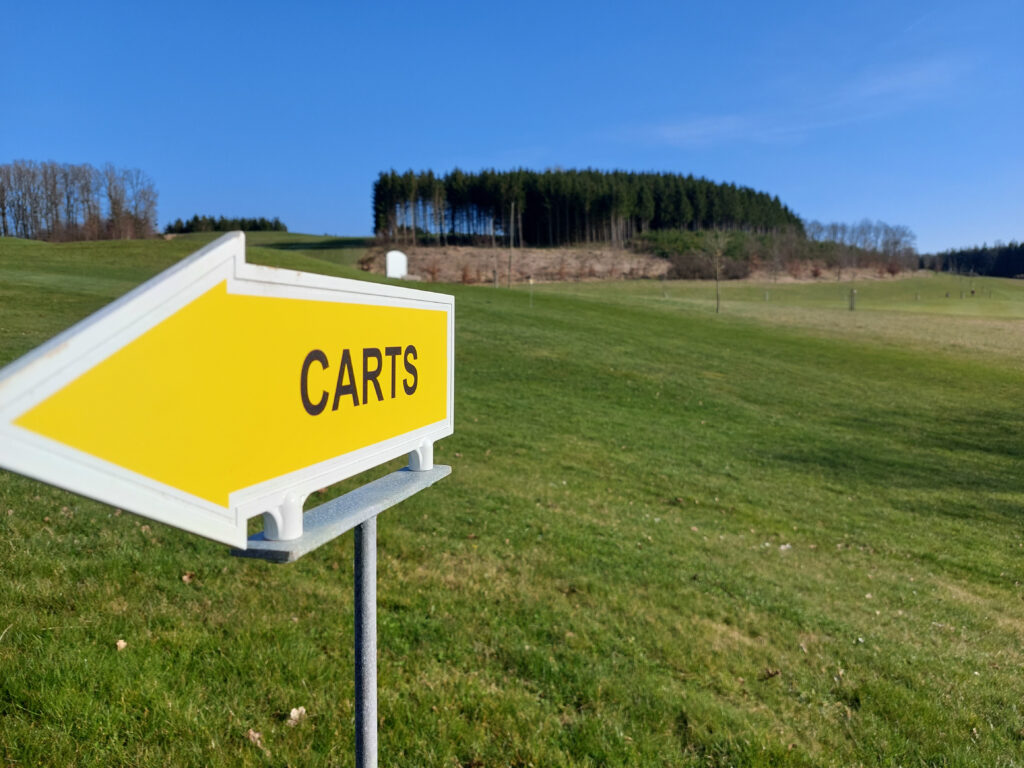 Golfplatz mit Richtungsschild Carts