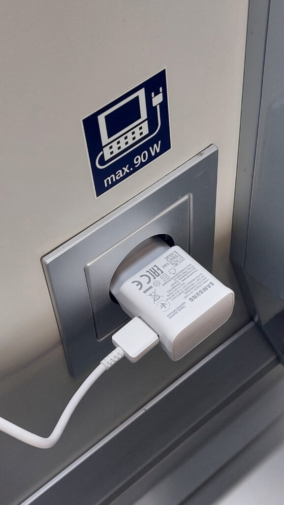 Ladegerät für das Smartphone in einer Steckdose im Zug