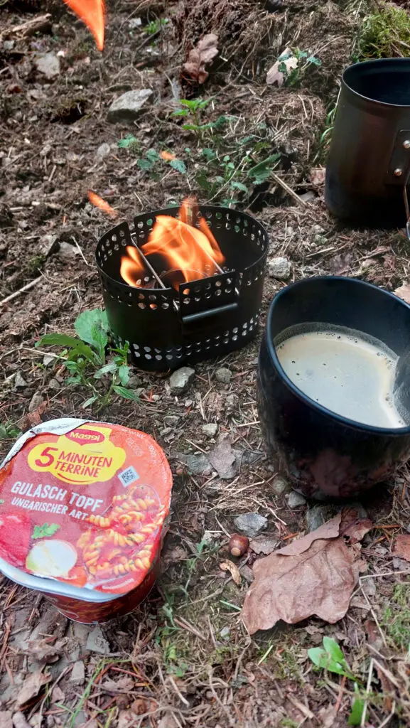 Brennender Trangia-Brenner in einem Crusader MK2 Kochsystem von BCV. Tasse Kaffee und eine 5-Minutenterrine