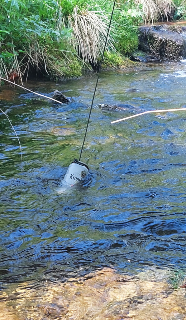 Getränkedose zum Kühlen ins Wasser gehängt. Ansicht von der Seite auf das gekühlte Getränk.