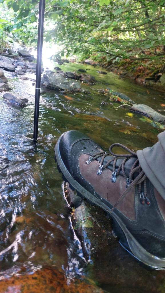 Bachüberquerung mit Hilfe eines Trekkingstocks
