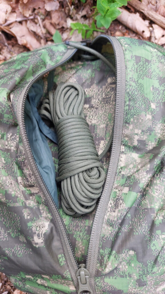 Packsack von Helikon-Tex in Pencott Wildwood mit Paracord, Tarp und kleinem Packsack mit Heringen.
