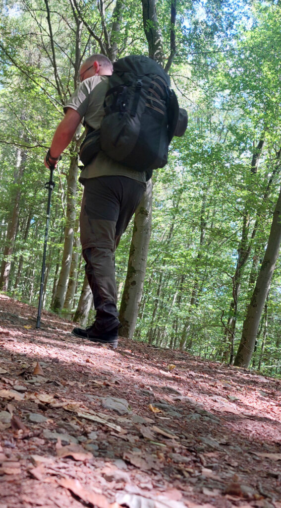 Thomas wandert den Berg hinauf. Trekkingstöcke sind hilfreich.